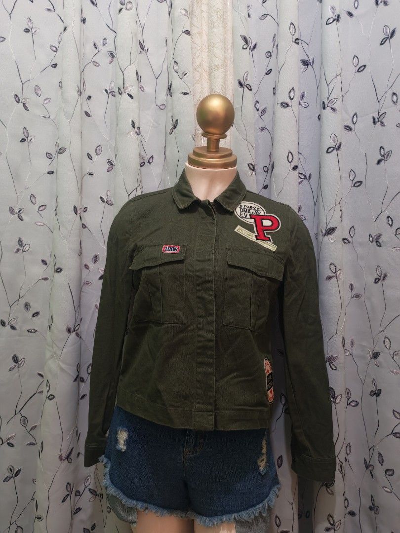 Forever 21 Olive Green Patched Utility Jacket Size S (Category: Coats, Jackets and Outerwear) located in Caloocan City. Submitted by _misskaye (Listing ID 1466160939, Image 1). Description: - Brand: Forever 21 - Size: S - Color: Olive green - Style: Utility jacket with button-up front, collar, and chest pockets - Details: Cool embroidered patches (big red 'P', California, 1986) - Condition: Great pre-loved condition - Perfect for: Casual everyday