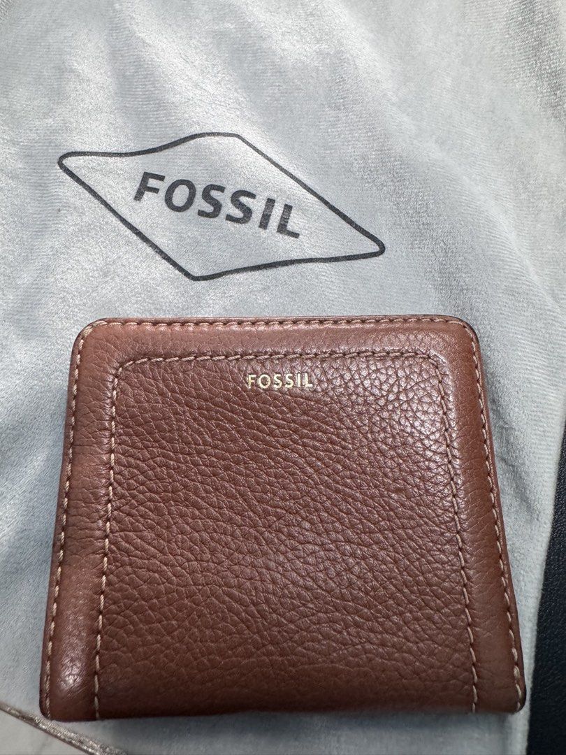 Fossil Brown Leather Wallet (Category: Wallets & Card holders) located in Naga. Submitted by danisj (Listing ID 1466278976, Image 1). Description: - Brand: Fossil - Material: Brown pebbled leather with gold-tone hardware - Closure: Snap closure for main compartment - Exterior: Zippered coin pocket with branded pull tab - Interior: Multiple card slots and ID window - Condition: Clean lining inside - Fit: Compact size, fits easily in pockets or sma