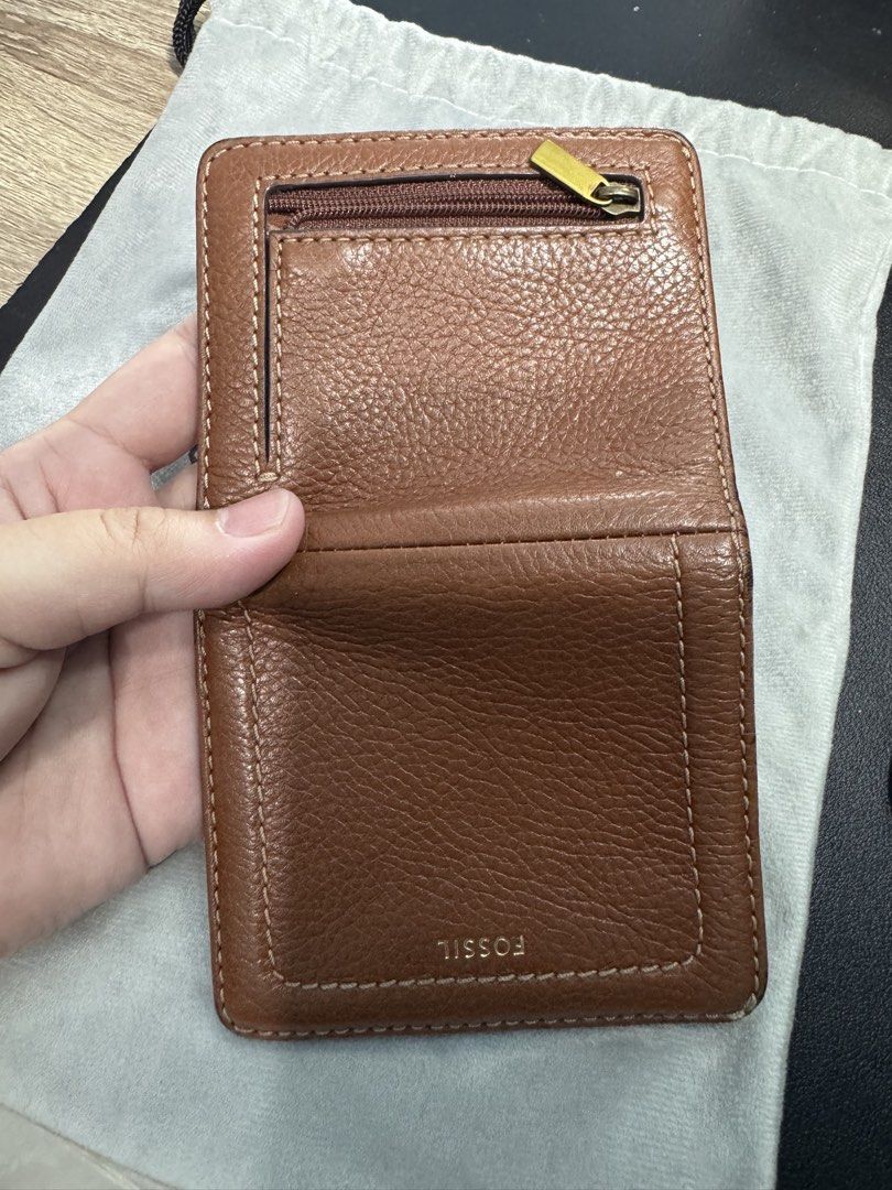 Fossil Brown Leather Wallet (Category: Wallets & Card holders) located in Naga. Submitted by danisj (Listing ID 1466278976, Image 3). Description: - Brand: Fossil - Material: Brown pebbled leather with gold-tone hardware - Closure: Snap closure for main compartment - Exterior: Zippered coin pocket with branded pull tab - Interior: Multiple card slots and ID window - Condition: Clean lining inside - Fit: Compact size, fits easily in pockets or sma