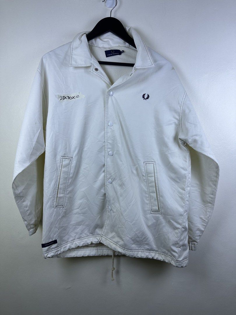 Fred Perry White Coach Jacket (Category: Coats, Jackets and Outerwear) located in Manila. Submitted by declutterpromax (Listing ID 1466221389, Image 1). Description: - Authentic Fred Perry white coach jacket - Features button-up front, slide pockets, and iconic embroidered laurel wreath logo - Designed with contrast dark topstitching, elastic cuffs, and an adjustable drawstring hem - Swipe for more details and send a message for inquiries!.