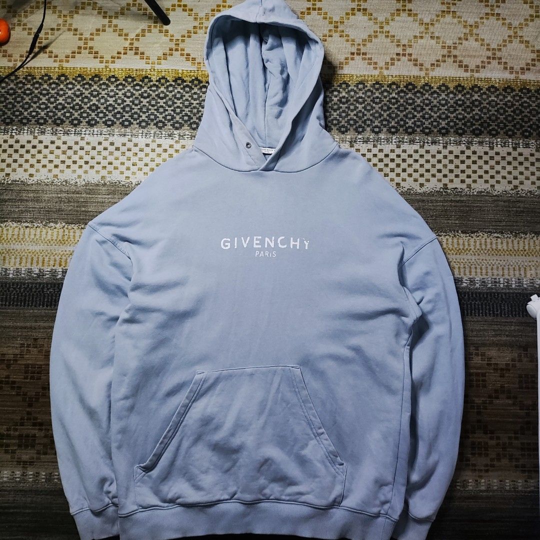 Givenchy Paris Blue Hoodie (Category: Coats, Jackets and Outerwear) located in Taguig. Submitted by althriftdailyloots94 (Listing ID 1466268591, Image 2). Description: - Need wash only - Size XL - Brand: Givenchy - Color: Light blue with white embroidered chest logo - Fit: Classic relaxed fit - Features: Front kangaroo pocket, adjustable drawstring hood, ribbed cuffs and hem - Condition: Great casual piece with inner brand tags attached - Shippin