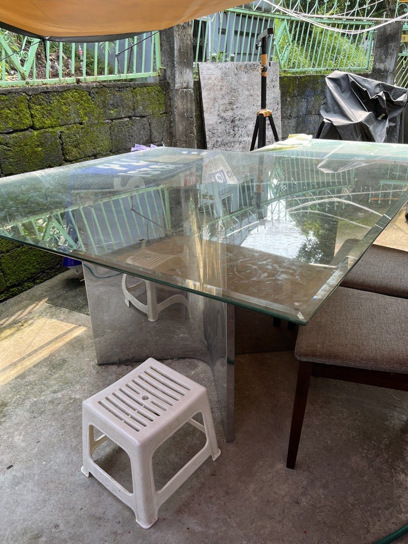 Glass top dining table with chrome base (Category: Tables & Sets) located in Manila. Submitted by sabrinaa20 (Listing ID 1466254679, Image 3). Description: - Modern square dining table - Thick glass top with normal surface wear (no cracks) - Shiny chrome metal pedestal base - Seats 8 comfortably - Sturdy, heavy build for maximum stability - Pick up only (due to size and weight).