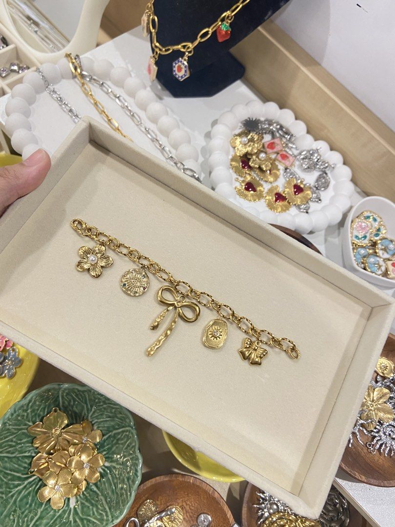 Gold Charm Bracelet (Category: Bracelets) located in Manila. Submitted by pandaaa_loo (Listing ID 1466272821, Image 2). Description: - Gold-tone chain link bracelet - Cute charms: strawberries, gem flowers, sunburst crystal star, and enamel floral pendants - Solid and chunky links with a secure clasp - Perfect for everyday wear or stacking with other accessories.
