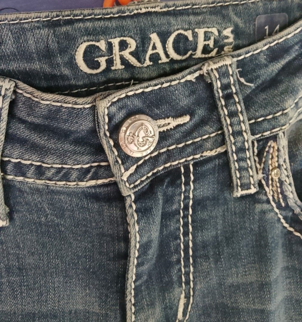 Grace in LA Jeans Size 14 (Category: Jeans) located in Manila. Submitted by keencrystal.595c28 (Listing ID 1466310100, Image 2). Description: - Brand: Grace in LA - Size: 14 - Wash: Medium dark with front whiskering - Details: Embellished back pockets with winged embroidery and rhinestone studs, white contrast stitching - Material: 72% cotton, 26% polyester, 2% elastane - Features: Button closure, belt loops, standard 5-pocket design.