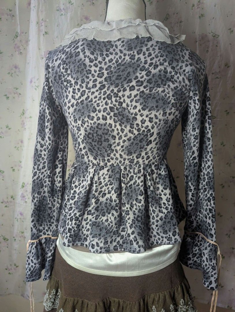 Grey Leopard Print Ruffle Cardigan Top (Category: Coats, Jackets and Outerwear) located in Manila. Submitted by drei_thrift (Listing ID 1466197950, Image 2). Description: - Grey and white leopard print - Long sleeves with adjustable tie cuffs - Ruffle trim wide neckline - Button-up front with pearl buttons - Flared peplum waist silhouette - Soft, lightweight knit material.