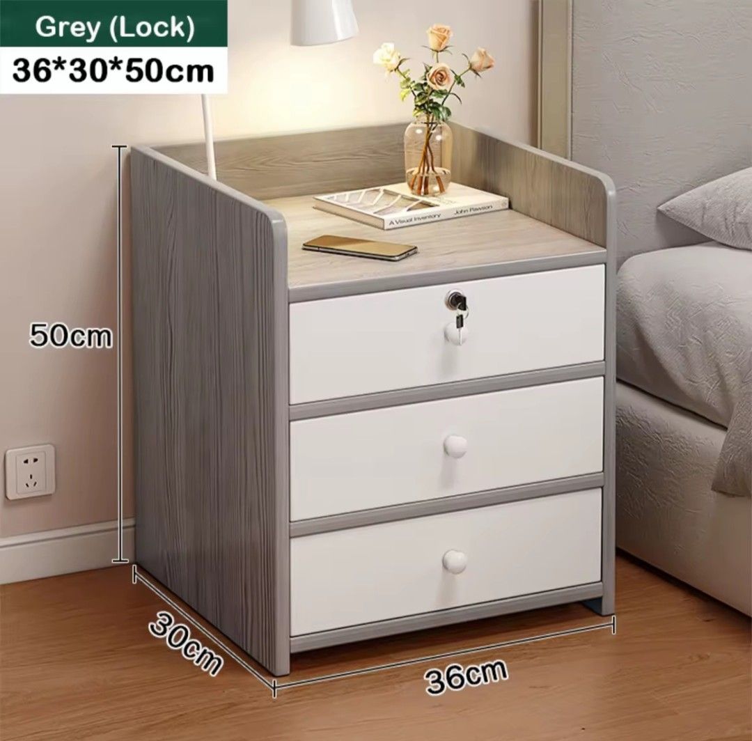 Grey Wooden Bedside Table with 3 Drawers and Lock (Category: Shelves, Cabinets & Racks) located in Quezon City. Submitted by camillefajardo13 (Listing ID 1466282105, Image 1). Description: - Grey bedside cabinet with solid wooden construction - Dimensions: 36cm (W) x 30cm (D) x 50cm (H) - Features 3 clean white drawers and an open top shelf for books or decor - Top drawer includes a working lock and key for security - Compact size that fits nicel