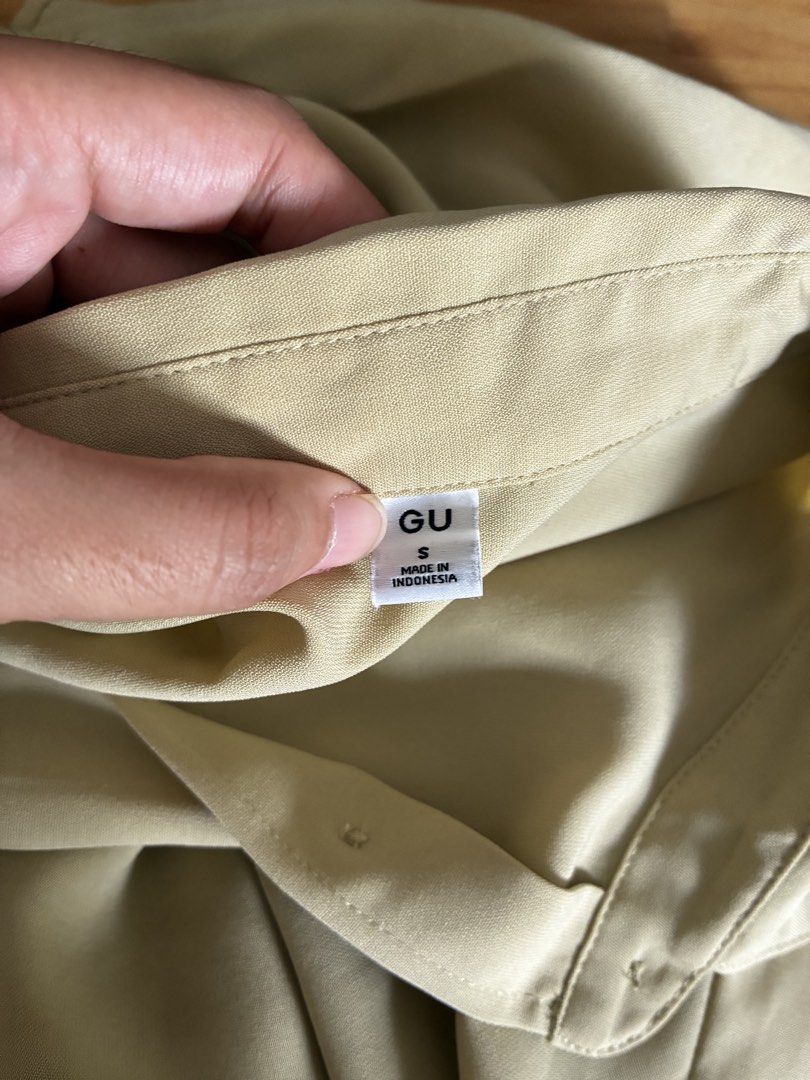 GU Drape Shirt (Category: Shirts) located in Dasmarinas. Submitted by fermosaclothing (Listing ID 1466166359, Image 3). Description: - Brand: GU - Color: Light Green - Size: S - Material: Lightweight polyester (Made in Indonesia) - Sleeve: Short sleeves with stylish folded cuffs - Details: Classic collar, front button closure, curved hemline - Condition: Excellent, buyer-friendly piece for everyday wear.