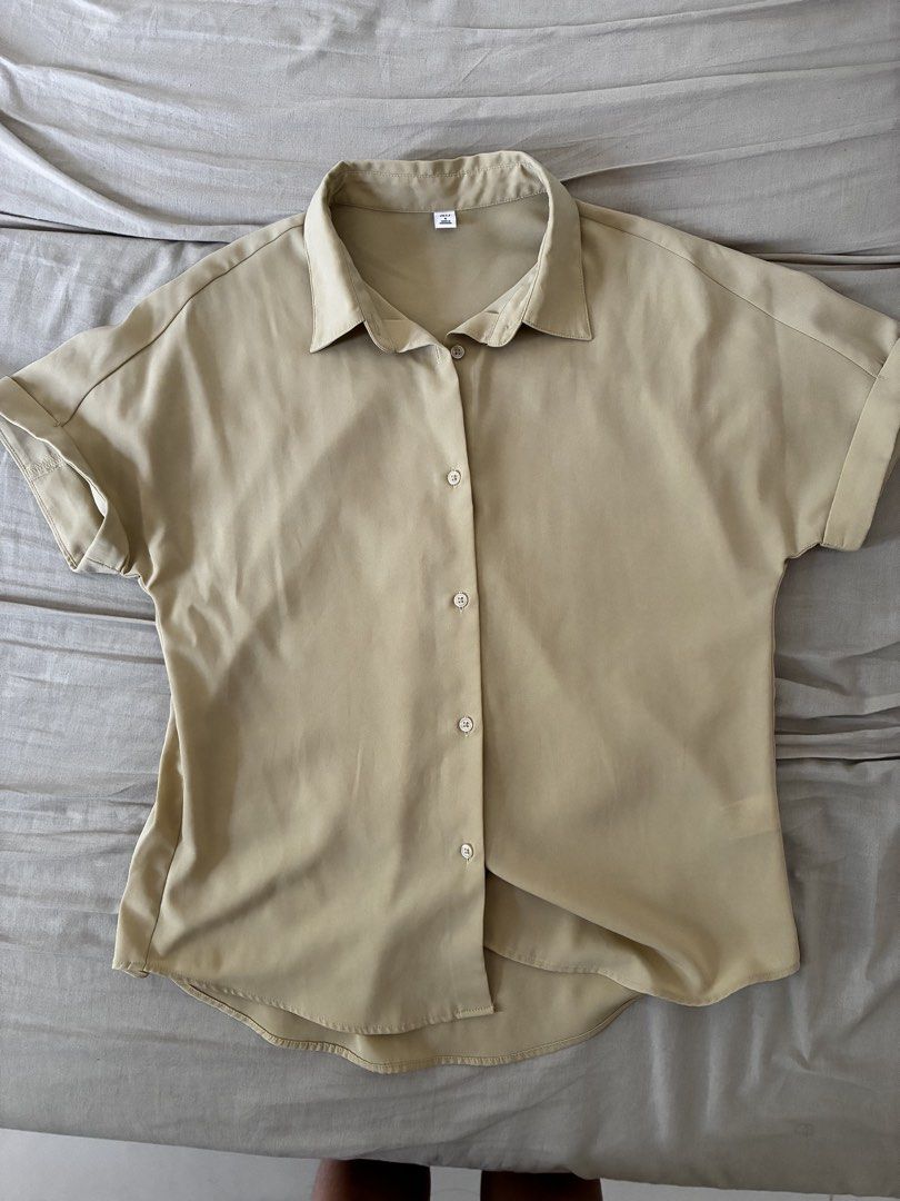 GU Drape Shirt (Category: Shirts) located in Dasmarinas. Submitted by fermosaclothing (Listing ID 1466166359, Image 2). Description: - Brand: GU - Color: Light Green - Size: S - Material: Lightweight polyester (Made in Indonesia) - Sleeve: Short sleeves with stylish folded cuffs - Details: Classic collar, front button closure, curved hemline - Condition: Excellent, buyer-friendly piece for everyday wear.