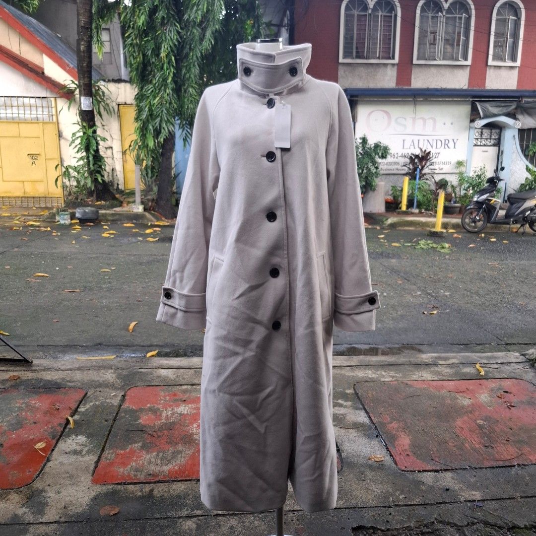 GU Melton Balmacaan Coat (Category: Coats, Jackets and Outerwear) located in Manila. Submitted by arzhelfromsjs (Listing ID 1466231335, Image 2). Description: - Color: Classic beige - Style: Long trench coat with front buttons and lapel collar - Features: Functional pockets and buttoned strap details on sleeves - Interior: Fully lined with a smooth fabric finish - Best for: Great layering piece for cooler weather.