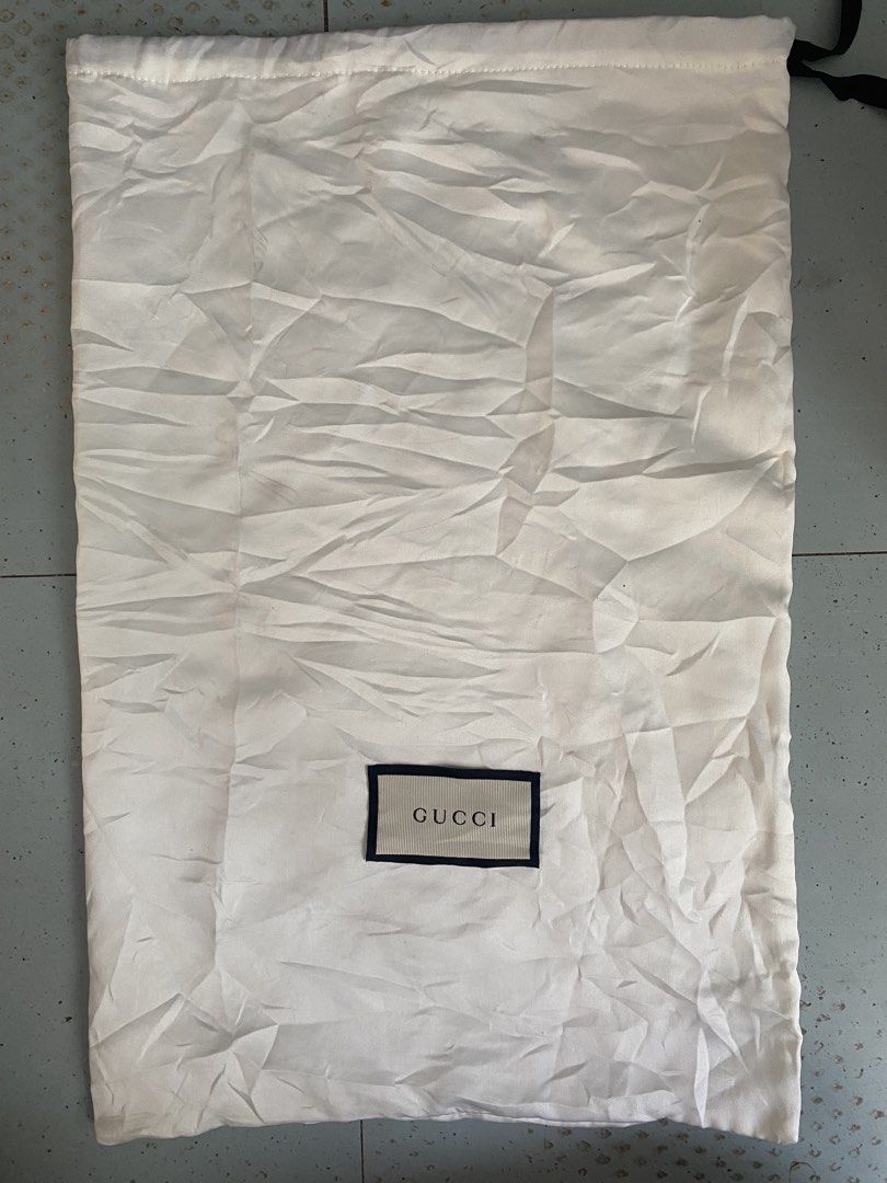Gucci Dust Bag White Cotton (Category: Luxury Bags & Wallets) located in Davao. Submitted by dandeshop (Listing ID 1466217123, Image 1). Description: - Authentic white Gucci dust bag - Secure top drawstring closure - Features inner fabric label with Gucci lettering and care instructions - Features rectangular Gucci logo label near the bottom - Clean condition overall with minor wrinkles from storage.