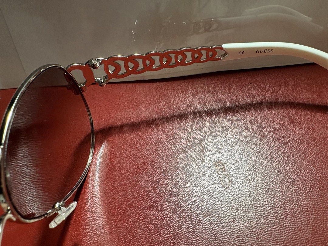 Guess GU 7255 Aviator Sunglasses with Red Case (Category: Sunglasses & Eyewear) located in Paranaque City. Submitted by heisam99 (Listing ID 1466314108, Image 3). Description: - Brand: Guess - Model: GU 7255 SI-35F (63-13-125) - Style: Classic aviator with gradient lenses - Frame: Silver-tone metal with trendy chain-link detail on temples - Details: White temple tips featuring GUESS and CE branding - Inclusions: Original red pebbled leatherette h