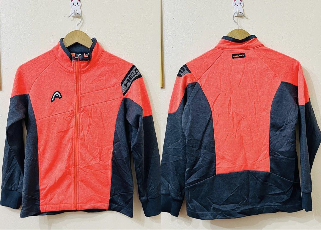 HEAD Sport Jacket Orange Black Zip Up (Category: Babies & Kids Fashion) located in Manila. Submitted by bengirlclothing (Listing ID 1466198375, Image 1). Description: - Brand: HEAD - Color: Vibrant orange and dark grey - Design: Contrast panel design with striped shoulder branding and logo prints on chest and rear collar - Features: Full front zip closure, stand-up collar, ribbed cuffs and hem - Size: 140 - Condition: Great for sports or casual w