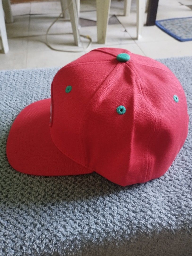 Hempire Snapback Cap Red Teal (Category: Caps & Hats) located in Manila. Submitted by happycaps (Listing ID 1466172127, Image 2). Description: - Brand: Hempire Alpine Headwear - Style: Red snapback cap with flat teal-undervisor brim - Front Details: Central Rolling Agency patch with rolling hands graphic and "roll free, roll often" text - Interior: All-over weed leaf pattern lining - Closure: Adjustable teal snap closure with small fabric tag - C