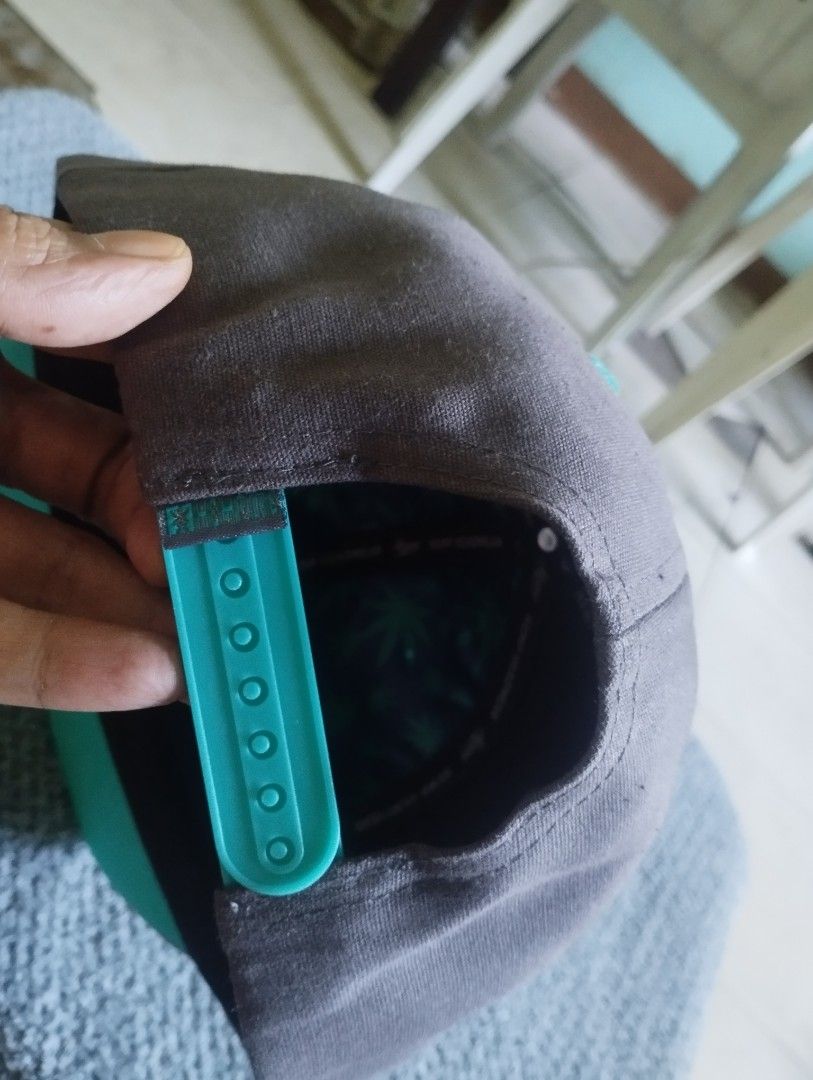 Hempire Snapback Hat Gray Teal (Category: Caps & Hats) located in Manila. Submitted by happycaps (Listing ID 1466172526, Image 3). Description: - Brand: Hempire - Style: Gray snapback cap with adjustable snap closure - Design: Central Rolling Agency patch on the front with cartoon hands rolling a joint - Details: Eye-catching teal eyelets, top button, strap, underbrim, and side tag - Interior: Branded taped seams and a green weed leaf pattern lin