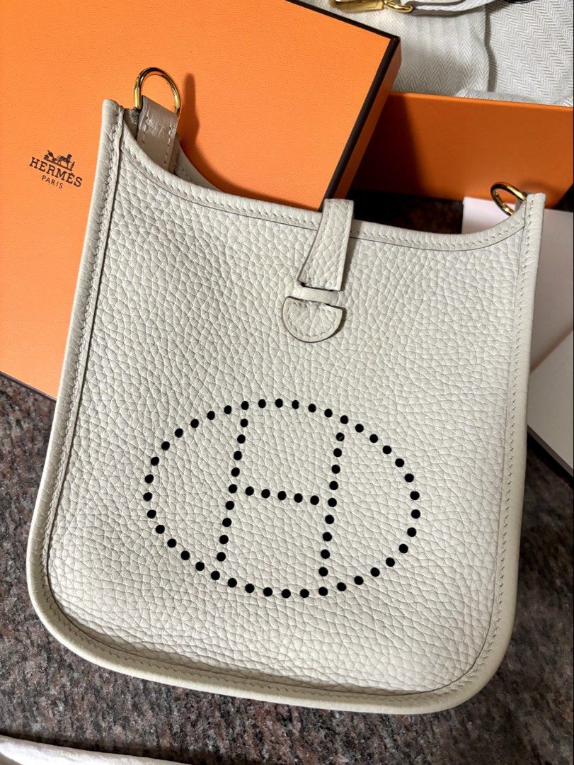 Hermes Mini Evelyne 金扣 奶昔白 Craie （分類：手袋及銀包）位於 Hong Kong。 由 charlottebubble 提交（商品編號 1466295950，圖片 1）。簡介： 🤍 Hermes Mini Evelyne Craie 奶昔白 金扣 TC皮 Stamp G (2026) 🐂 TC皮 🪝金扣 🛍️ 2026年購自深圳萬象城專門店 💯 100%正貨 authentic ✨ 肩帶全新未開，內裏有正常使用痕跡，外面狀態良好 🎁 有盒、塵袋、price tag 及包裝 ✅ 沒有單 ❌ 🔍 可以陪驗（費用請自理） 面交地點互就。