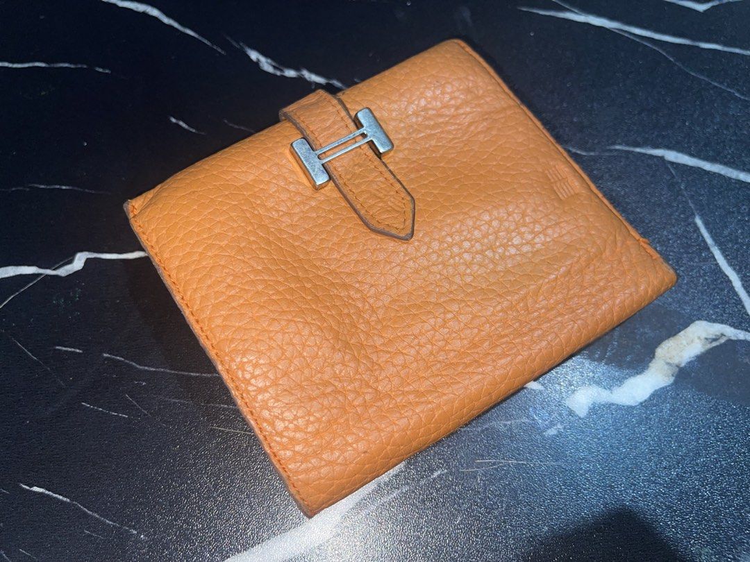 Hermes Orange Leather Compact Wallet (Category: Wallets & Card holders) located in Manila. Submitted by preloveditems_jem (Listing ID 1466253904, Image 3). Description: Authentic Hermes bi-fold wallet in iconic bright orange grained leather. Features a silver-toned zip pocket, multiple card slots, and a secure snap-tab closure. Shows very minor signs of gentle use. A gorgeous pop of color for your everyday essentials!.