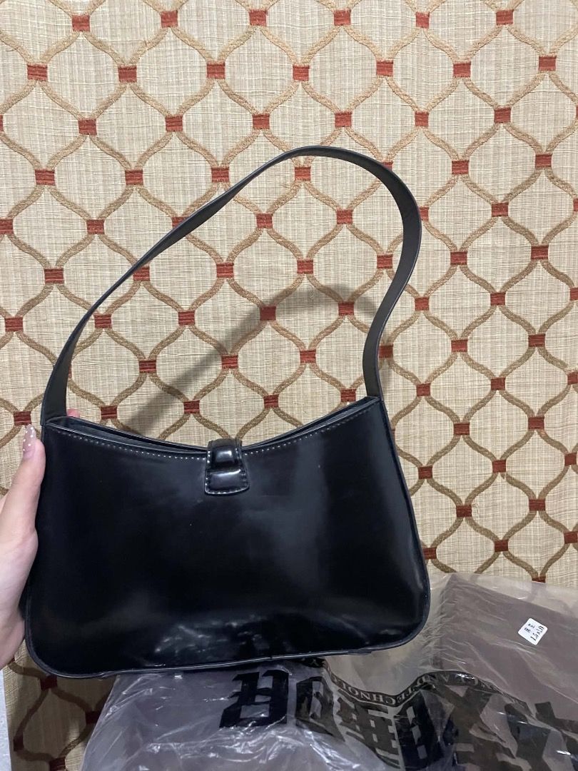 H&M Black glossy shoulder bag with turn-lock closure (Category: Shoulder Bags) located in Quezon City. Submitted by biabadoobee (Listing ID 1466264170, Image 2). Description: - Color: Glossy black - Material: Premium faux leather - Design: Structured rectangular shape with rounded corners and a single top shoulder strap - Closure: Elegant gold-tone metal turn-lock on the front flap - Size: Compact, ideal for daily essentials and versatile for any