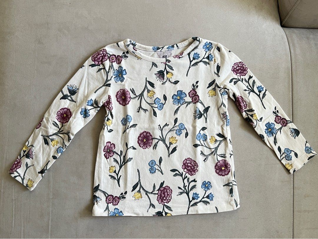 H&M Floral Long Sleeve Top (Category: Babies & Kids Fashion) located in San Fernando. Submitted by wearvfs (Listing ID 1466205320, Image 2). Description: - Brand: H&M - Size: 2T / EUR 92 - Material: Soft cotton - Design: Off-white with purple, blue, and yellow floral vine pattern and round neckline - Measurements: ~28 cm pit to pit, ~35 cm length .
