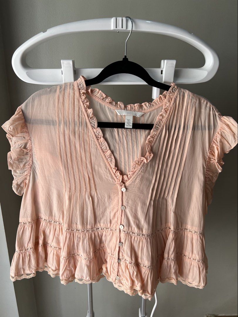 H&M Peach Ruffle Button-Down Blouse Size L (Category: Blouses) located in Davao. Submitted by bengscloset (Listing ID 1466202107, Image 3). Description: Brand: H&M Size: L Color: Peach Details: Ruffles, pintuck chest, layered tiered ruffles with lace trim & cropped style Condition: Clean and well-kept 📌 No rush shipping. 📦 Shipping fee c/o buyer. 📍Davao City 💌 Feel free to message me for additional photos/details. Thank you for checking out m