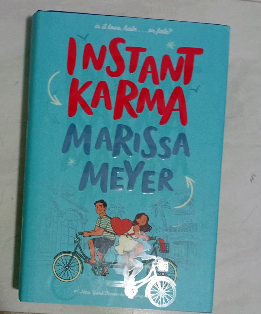 Instant Karma by Marissa Meyer (Category: Storybooks) located in Manila. Submitted by luckyfox-3a3e (Listing ID 1466310105, Image 2). Description: - Title: YA Contemporary Romance Novel by Marissa Meyer - Format: Hardcover edition with a bright blue tandem bicycle cover - ISBN: 9781250618818 - Condition: Clean pages, solid spine, good reading copy - Retail Price: P 499.00.