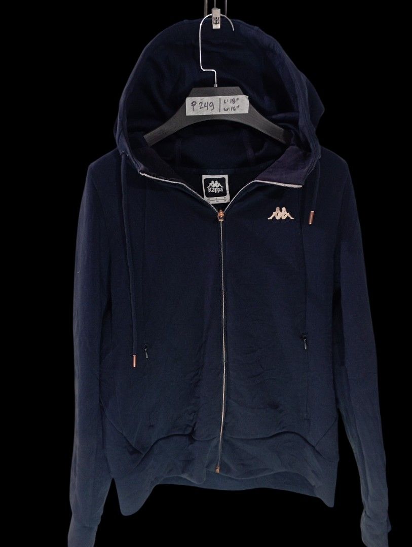 Kappa Navy Blue Zip-Up Hoodie (Category: Coats, Jackets and Outerwear) located in Rodriguez. Submitted by enzo.tv (Listing ID 1466325868, Image 2). Description: - Brand: Kappa - Color: Navy blue - Details: Rose gold zipper, drawstring tips, chest logo, and sleeve cursive text - Measurements: 18 inches length, 16 inches width - Condition: Great everyday piece, easy to style.