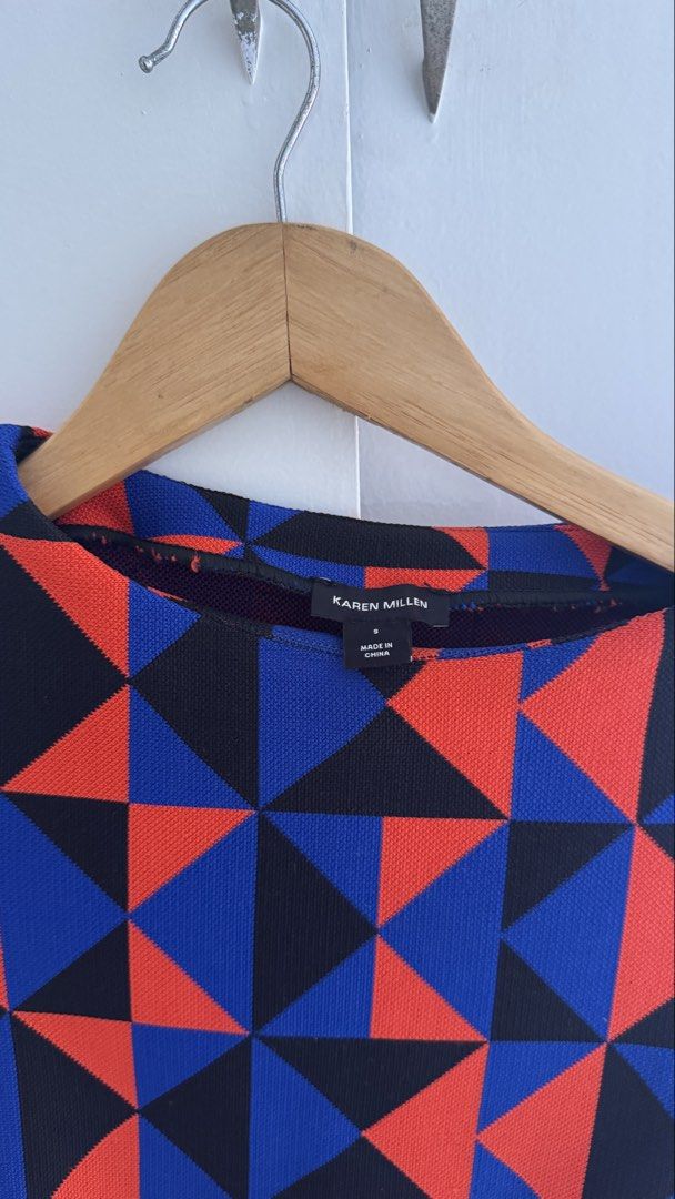 Karen Millen Geometric Pattern Dress Size S (Category: Dresses) located in Quezon City. Submitted by meezck (Listing ID 1466185554, Image 2). Description: - Brand: Karen Millen - Size: S - Colorway: Bold red, blue, and black geometric color-block pattern - Design: Short sleeves, round neckline, fitted silhouette, and wrap-style front - Details: Eye-catching gold lion-embossed decorative buttons - Closure: Convenient zipper fastening along the sid