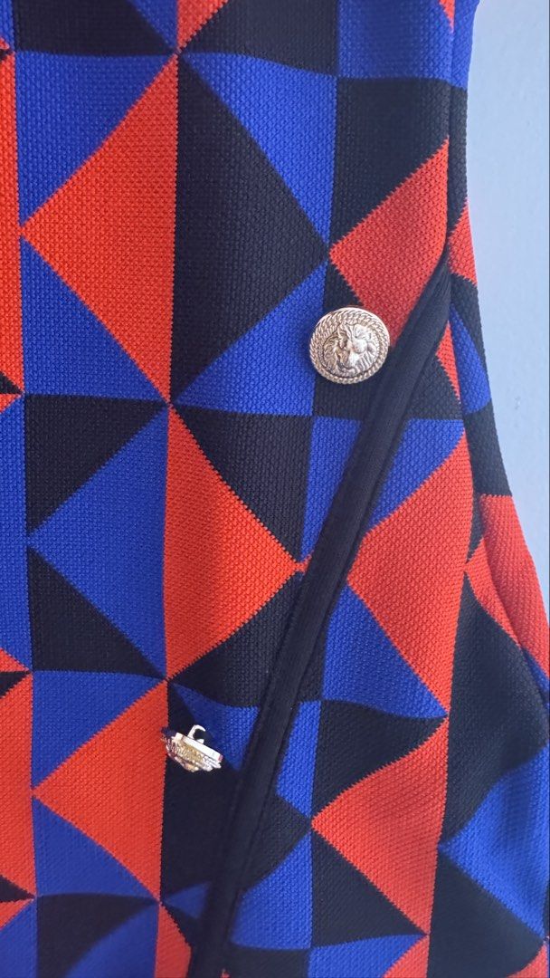 Karen Millen Geometric Pattern Dress Size S (Category: Dresses) located in Quezon City. Submitted by meezck (Listing ID 1466185554, Image 3). Description: - Brand: Karen Millen - Size: S - Colorway: Bold red, blue, and black geometric color-block pattern - Design: Short sleeves, round neckline, fitted silhouette, and wrap-style front - Details: Eye-catching gold lion-embossed decorative buttons - Closure: Convenient zipper fastening along the sid