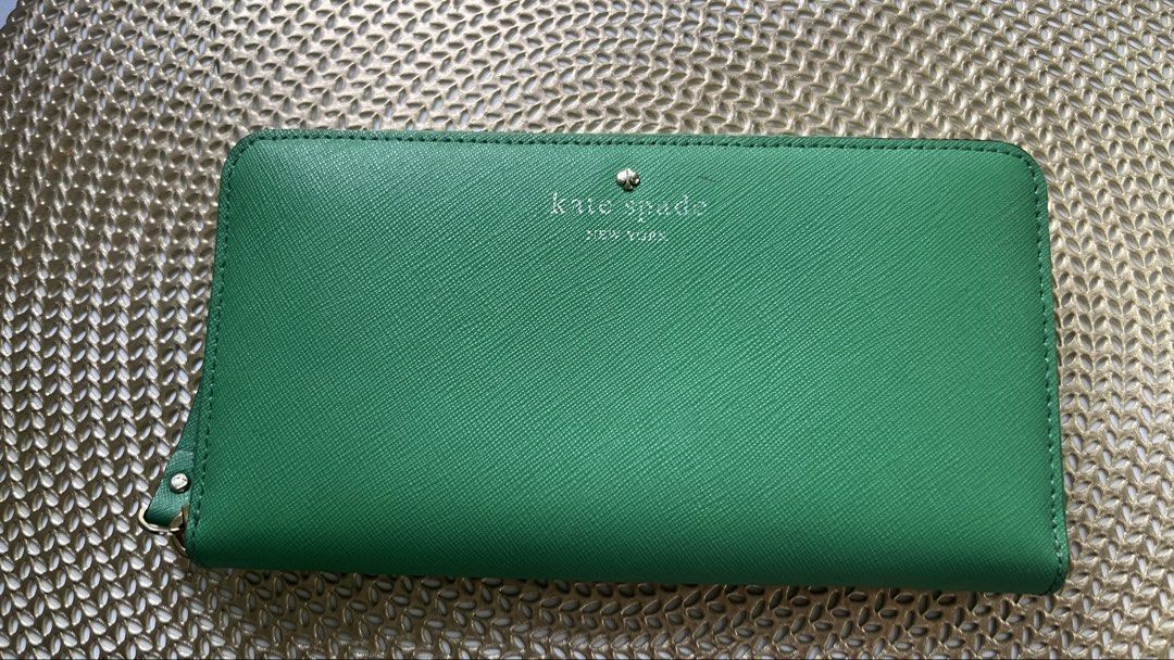 Kate Spade Green Zip Around Wallet (Category: Wallets & Card holders) located in Manila. Submitted by skin_care_depot (Listing ID 1466310077, Image 3). Description: Authentic Kate spade long wallet. Preloved but well loved. Kept in the drawer, not really used. Bought from Rustans Makati. Decluttering. - Brand: Kate Spade - Material: Premium Saffinado leather in a chic green shade - Hardware: Gold-tone hardware and zipper pull - Interior: Multiple