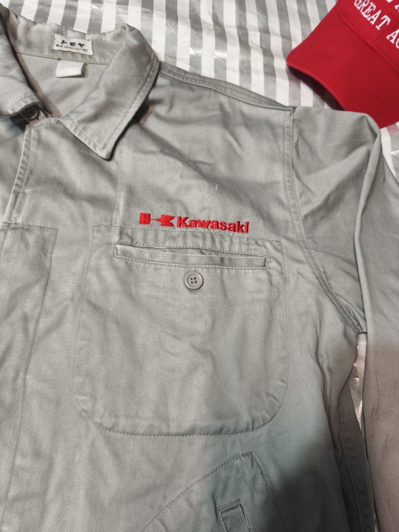 Kawasaki Vintage Grey Workwear Jacket (Category: Coats, Jackets and Outerwear) located in Baguio. Submitted by boneteezandharmony (Listing ID 1466330349, Image 2). Description: - Color: Grey - Details: Red Kawasaki embroidery on chest pocket, button-up front, collar, and large front pockets - Origin: Japanese tagging inside the collar - Condition: Light spotting and stains on front and sleeves - Style: Rugged mechanic / utility wear.
