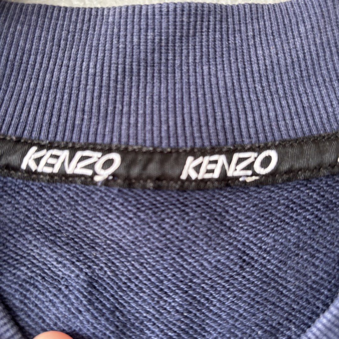 Kenzo paris authentic (Category: Coats, Jackets and Outerwear) located in San Fernando. Submitted by diff.thr1ft (Listing ID 1466170317, Image 3). Description: - Brand: Authentic Kenzo Paris - Color: Navy Blue - Origin: Made in Portugal - Design: Large white Kenzo Paris logo graphic on the back with unique V-neck collar - Condition: Well-maintained, excellent quality as shown in pictures - Perfect for casual wear and streetwear styling Issue cut 