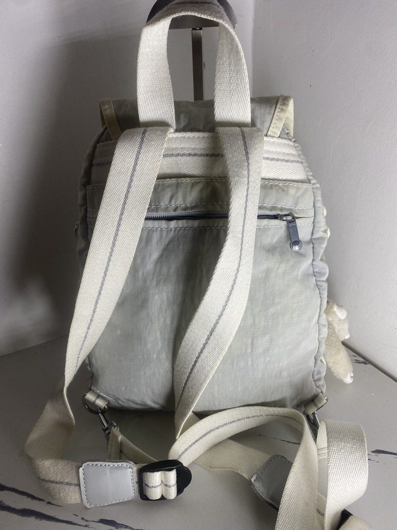 Kipling live.light Backpack White Grey (Category: Backpacks) located in Manila. Submitted by onfleekapparelph (Listing ID 1466168781, Image 3). Description: - Brand: Kipling - Color: Light Grey and White - Closure: Flap with magnetic snap - Pockets: Dual front zip pockets + inner zip pocket - Interior: Stylish black and white striped lining - Straps: Adjustable striped straps with top carry handle - Inclusion: Signature fuzzy monkey keychain - Co