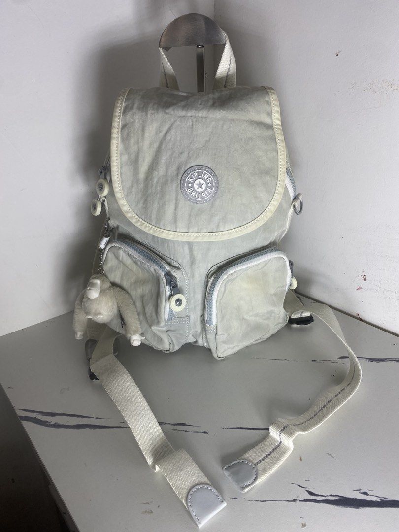Kipling live.light Backpack White Grey (Category: Backpacks) located in Manila. Submitted by onfleekapparelph (Listing ID 1466168781, Image 1). Description: - Brand: Kipling - Color: Light Grey and White - Closure: Flap with magnetic snap - Pockets: Dual front zip pockets + inner zip pocket - Interior: Stylish black and white striped lining - Straps: Adjustable striped straps with top carry handle - Inclusion: Signature fuzzy monkey keychain - Co