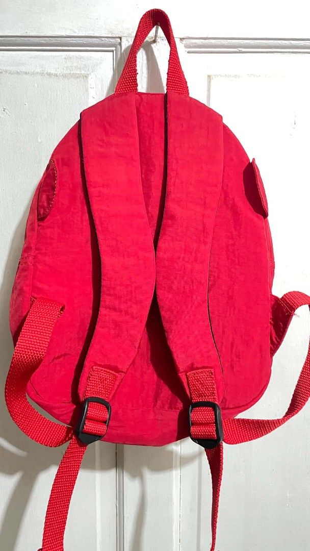 Kipling Red Monster Googly Eyes Backpack (Category: Backpacks) located in Manila. Submitted by xtinamendo00659 (Listing ID 1466287442, Image 3). Description: - Brand: Kipling mini backpack - Color: Bright red - Design: Quirky monster eyes and mouth zippered pocket - Material: Clean crinkle nylon fabric - Inclusion: Signature matching red monkey keychain charm - Hardware & Straps: Adjustable shoulder straps with black plastic hardware - Condition: