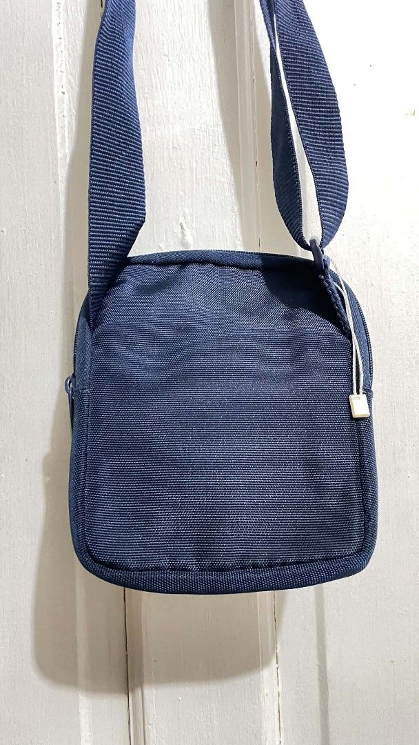 Lacoste Navy Blue Crossbody Bag (Category: Cross-body Bags) located in Manila. Submitted by xtinamendo00659 (Listing ID 1466287155, Image 3). Description: - Authentic navy blue Lacoste crossbody bag made from durable fabric - Adjustable shoulder strap for a custom and comfortable fit - Front zipper pocket for quick access to essentials like keys and cards - Secure main zipper compartment for your phone and wallet - Features the classic tonal Laco