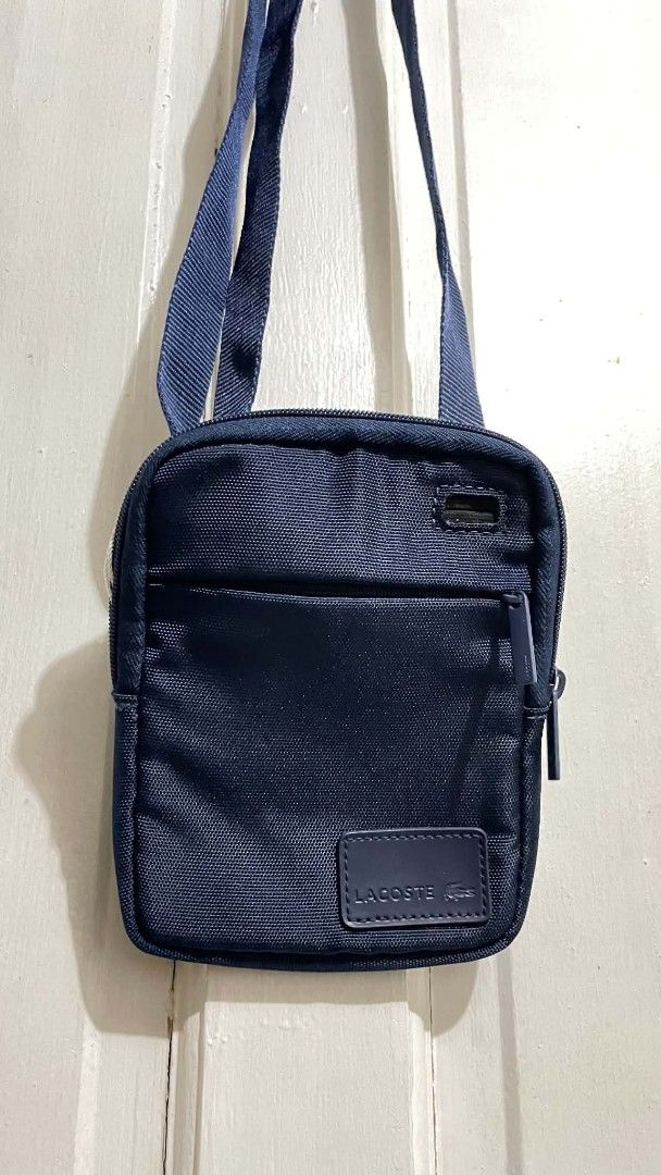 Lacoste Navy Blue Crossbody Bag (Category: Cross-body Bags) located in Manila. Submitted by xtinamendo00659 (Listing ID 1466287155, Image 2). Description: - Authentic navy blue Lacoste crossbody bag made from durable fabric - Adjustable shoulder strap for a custom and comfortable fit - Front zipper pocket for quick access to essentials like keys and cards - Secure main zipper compartment for your phone and wallet - Features the classic tonal Laco
