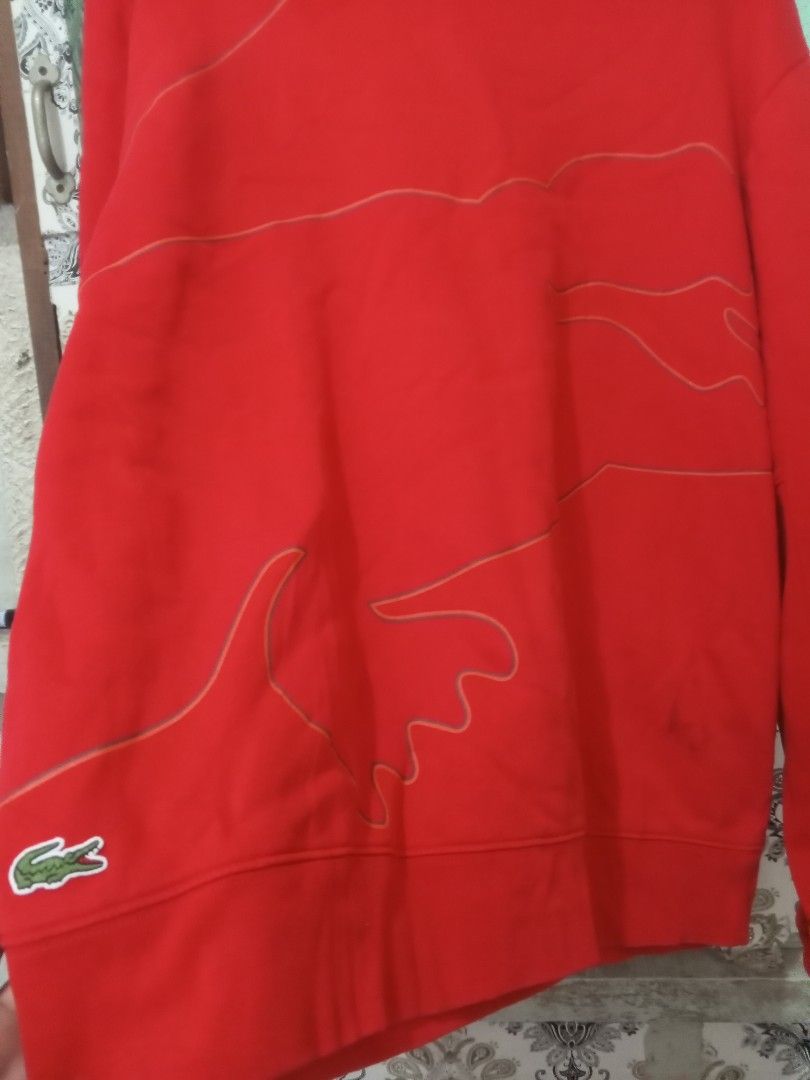Lacoste Sport Red Sweatshirt (Category: Coats, Jackets and Outerwear) located in Baguio. Submitted by opraahgayle (Listing ID 1466213711, Image 2). Description: - Brand: Lacoste Sport - Color: Red with subtle tonal design lines - Size: FR 6 (US XL) - Style: Classic crewneck sweatshirt with ribbed collar, cuffs, and hem - Detail: Iconic embroidered crocodile logo near bottom left hem - Origin: Made in China - Condition: Excellent.