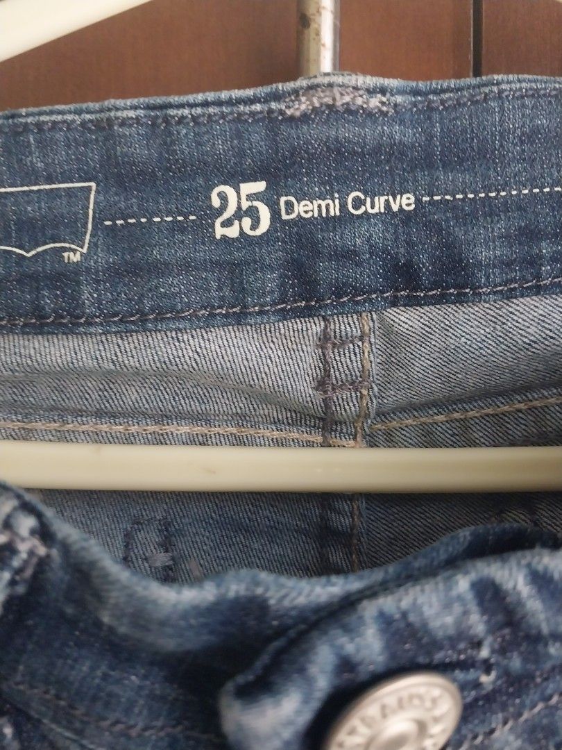 Levi's Demi Curve Jeans Size 25 (Category: Jeans) located in Aroroy. Submitted by imeea (Listing ID 1466158661, Image 3). Description: - Brand/Model: Levi's Demi Curve Jeans - Size: 25 (inner waist tag) - Fit/Style: Mid-rise, straight leg - Wash: Classic blue with natural fading on thighs and knees - Unique Details: Patterned pocket embroidery on the back and matching fabric trim on the front coin pocket - Condition: Lightly worn, great for every