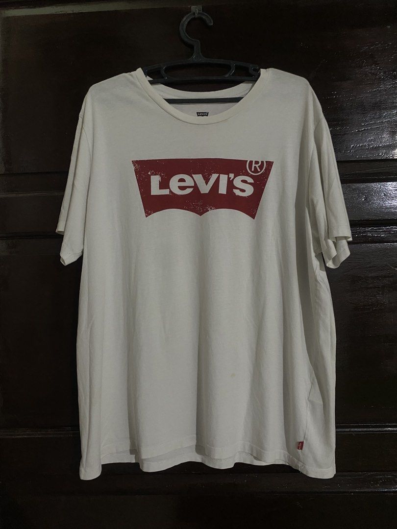 Levi's White T-Shirt with Red Logo (Category: Shirts) located in Manila. Submitted by cj_thrift10 (Listing ID 1466324155, Image 1). Description: - Brand: Levi's - Color: White with classic red winged logo - Fit: Men's standard sizing, regular crew neck - Details: Short sleeves, signature red tab on the bottom left hem - Condition: Clean fabric, no major defects, great for everyday casual wear.