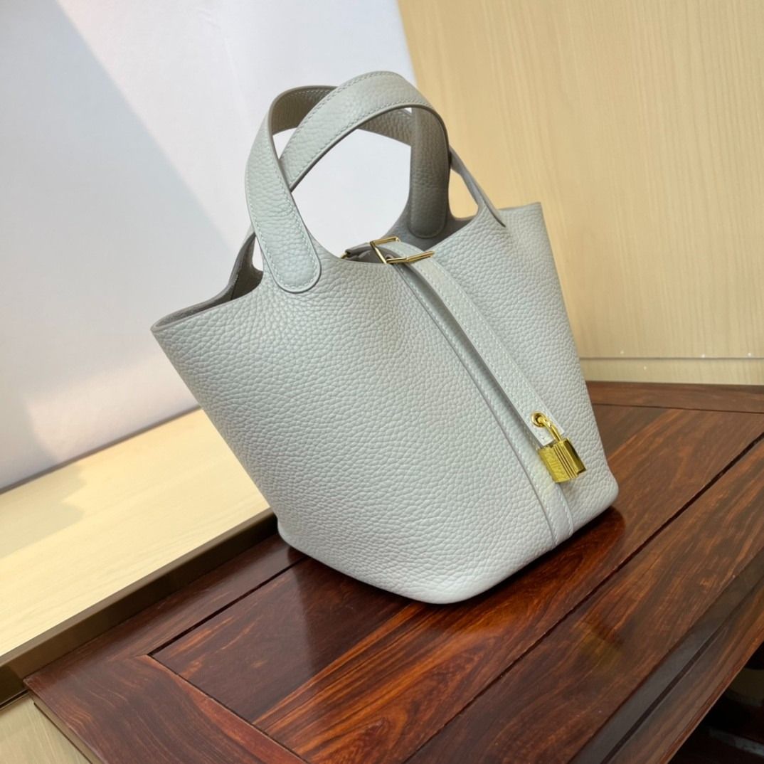 Light Grey Leather Bucket Bag with Gold Hardware (Category: Luxury Bags & Wallets) located in Las Pinas. Submitted by freemoon_7a5e73 (Listing ID 1466231250, Image 3). Description: - Material: Premium light grey pebbled leather with an unlined suede interior - Closure: Vertical strap with a secure golden padlock - Design: Clean silhouette with a structured base and dual top handles - Extra: Includes a matching removable base insert for added conv