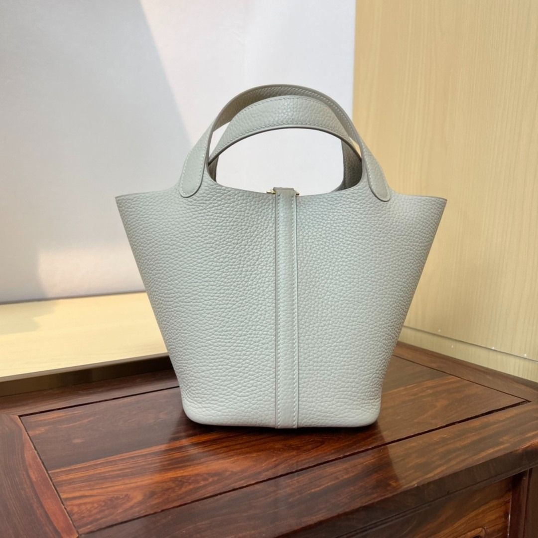 Light Grey Leather Bucket Bag with Gold Hardware (Category: Luxury Bags & Wallets) located in Las Pinas. Submitted by freemoon_7a5e73 (Listing ID 1466231250, Image 2). Description: - Material: Premium light grey pebbled leather with an unlined suede interior - Closure: Vertical strap with a secure golden padlock - Design: Clean silhouette with a structured base and dual top handles - Extra: Includes a matching removable base insert for added conv
