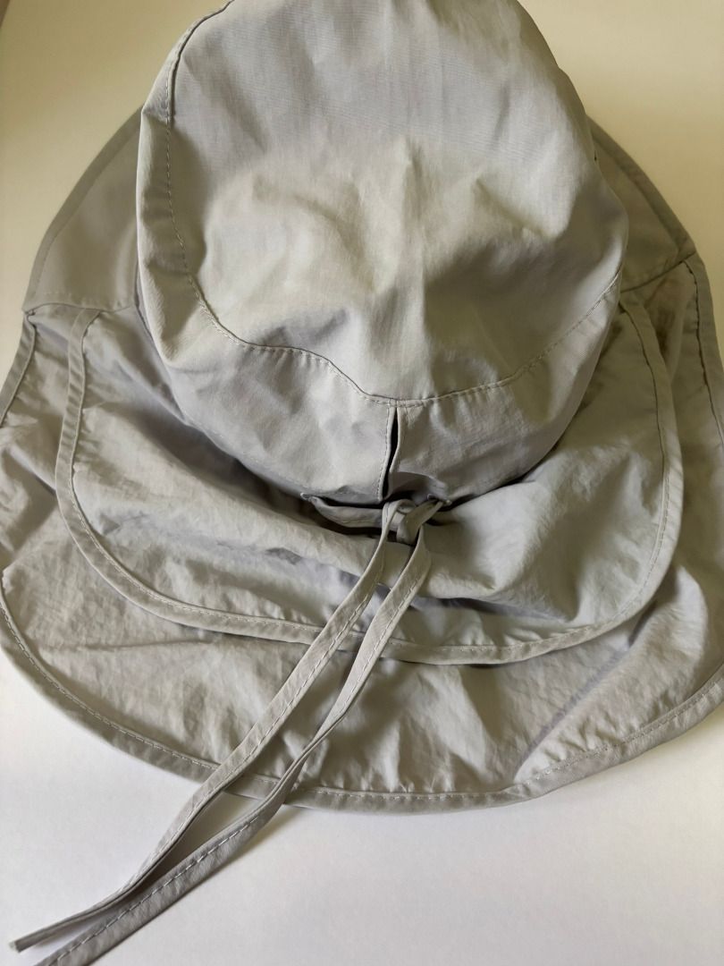 Light grey sun hat with neck flap and drawstring (Category: Hats & Beanies) located in Quezon City. Submitted by leahs.stuff (Listing ID 1466214816, Image 1). Description: - Color: Light Grey - Full coverage: Wide brim and attached neck flap - Secure fit: Adjustable chin straps with a toggle - Travel-friendly: Lightweight and easy to pack into any bag - Ideal for outdoor activities like gardening, hiking, and beach trips.