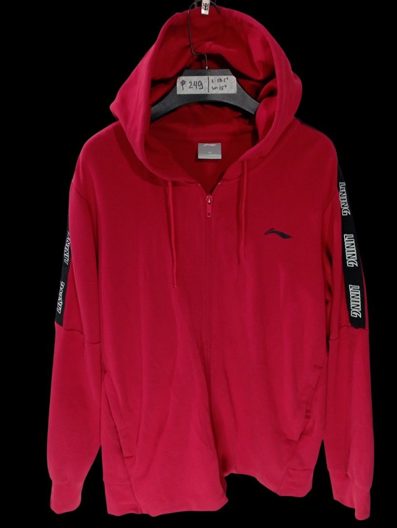 Li-Ning Red Zip-Up Hoodie (Category: Coats, Jackets and Outerwear) located in Rodriguez. Submitted by enzo.tv (Listing ID 1466324873, Image 2). Description: - Brand: Li-Ning - Color: Red with black branded tape on sleeves and small embroidered logo on chest - Size: Medium - Measurements: 19.5 inches length, 15 inches width - Features: Full zipper front, drawstring hood, front pockets, ribbed cuffs and hem - Condition: Good overall, clean and read