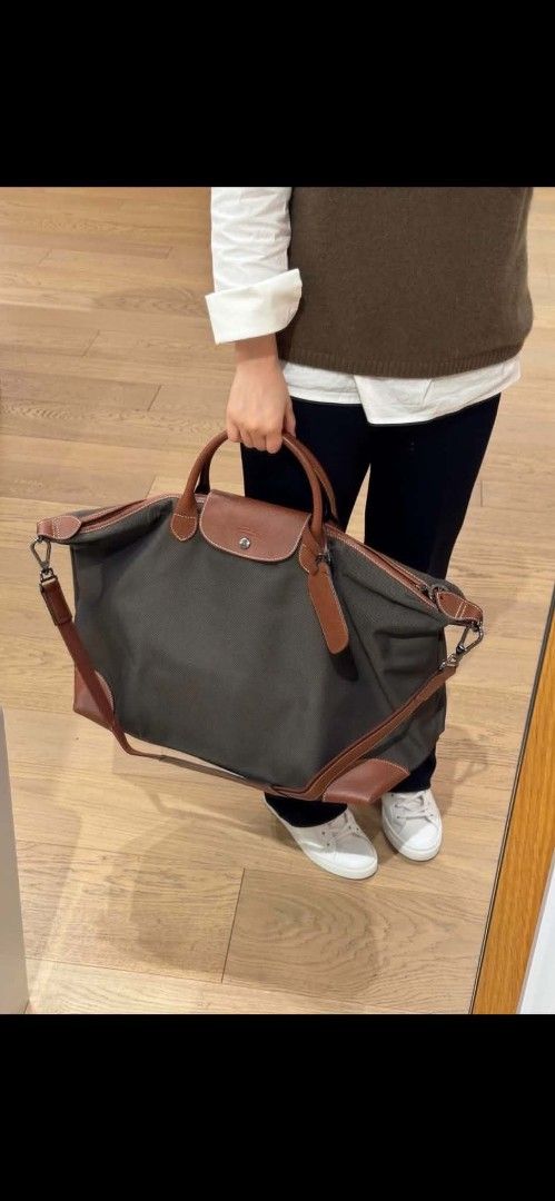 Longchamp Green Travel Bag (Category: Cross-body Bags) located in Paoay. Submitted by rvf1230 (Listing ID 1466230635, Image 1). Description: - Brand: Longchamp - Color: Deep green canvas with brown leather handles, corners, and strap - Condition: Clean inside and out - Interior: Black waterproof-style lining with multiple pockets - Closure: Full-length secure zip closure - Features: Includes a matching detachable shoulder strap with dark metal ha