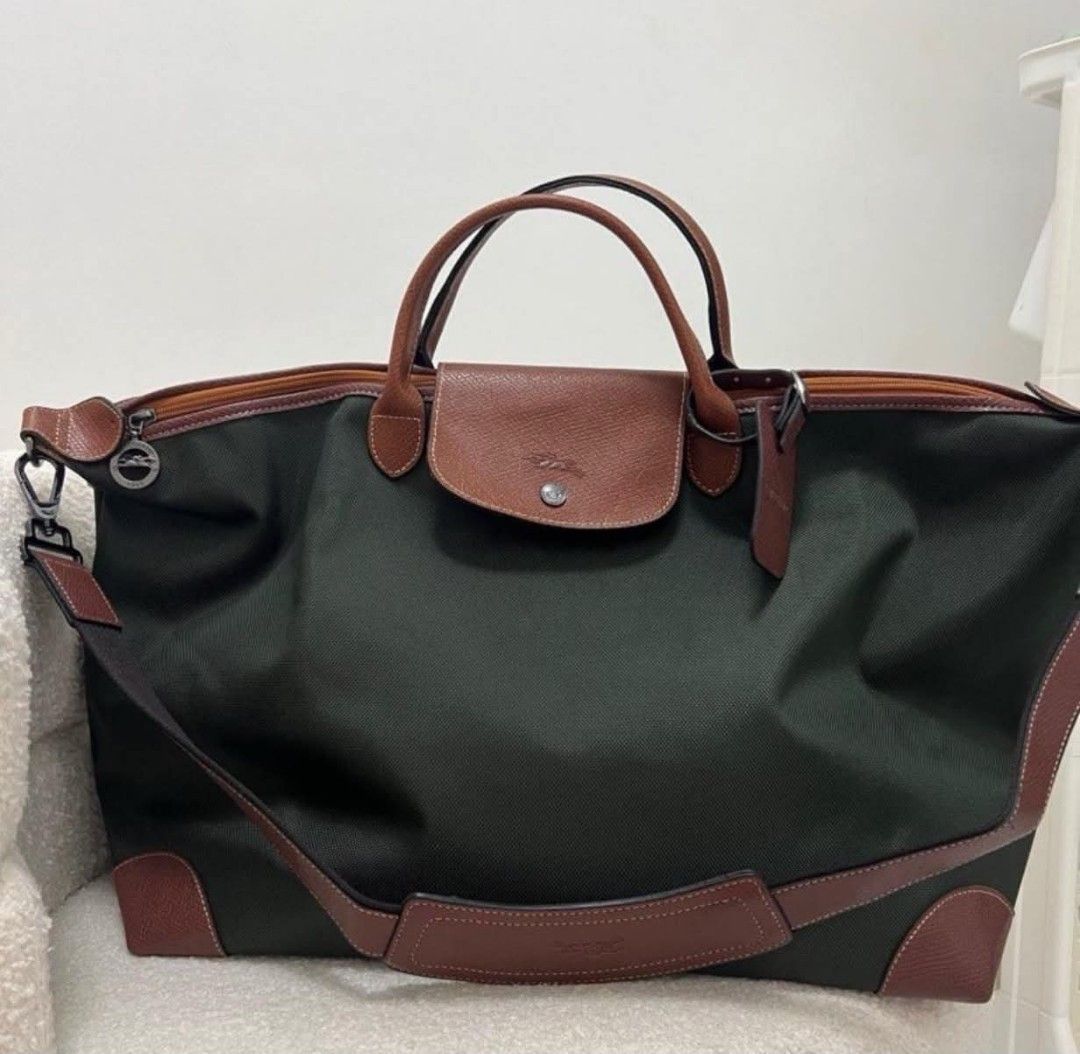 Longchamp Green Travel Bag (Category: Cross-body Bags) located in Paoay. Submitted by rvf1230 (Listing ID 1466230635, Image 2). Description: - Brand: Longchamp - Color: Deep green canvas with brown leather handles, corners, and strap - Condition: Clean inside and out - Interior: Black waterproof-style lining with multiple pockets - Closure: Full-length secure zip closure - Features: Includes a matching detachable shoulder strap with dark metal ha