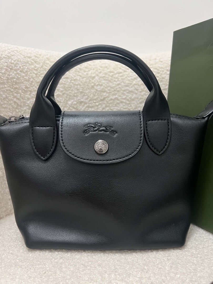 Longchamp Leather Small Crossbody Bag (Category: Luxury Bags & Wallets) located in Abulug. Submitted by jamiecammie (Listing ID 1466203155, Image 1). Description: Black leather Longchamp top handle bag. Silver tone hardware and embossed horse logo on the snap flap. Zip top closure with round pull stamped with Longchamp 1948. Removable shoulder strap included. Clean grain leather texture. Classic compact size for everyday essentials..
