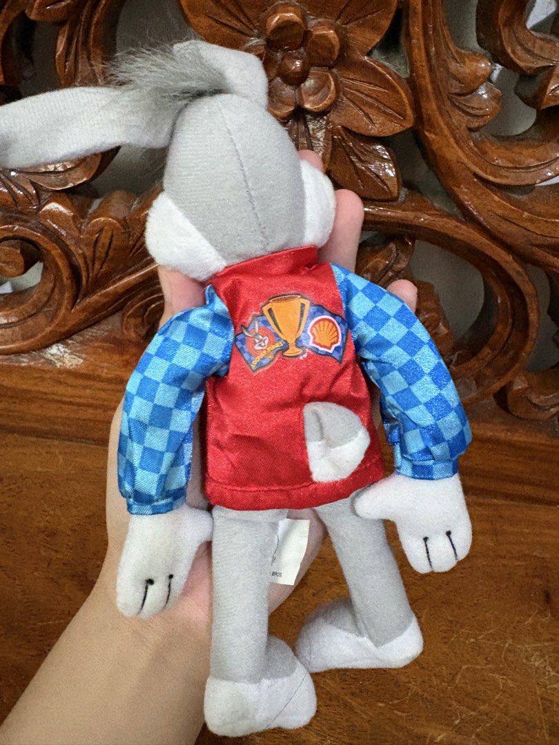 Looney Tunes Bugs Bunny Shell Racing Plush 1999 (Category: Plushies & Soft Toys) located in Quezon City. Submitted by rxyel (Listing ID 1466167622, Image 2). Description: - Vintage 1999 Warner Bros. Bugs Bunny plush toy - Wears a red vest over blue checkered sleeves - Features rare Shell oil branding and trophy graphic - Original tush tag attached with copyright details - Clean fabric, ideal for collectors and fans.