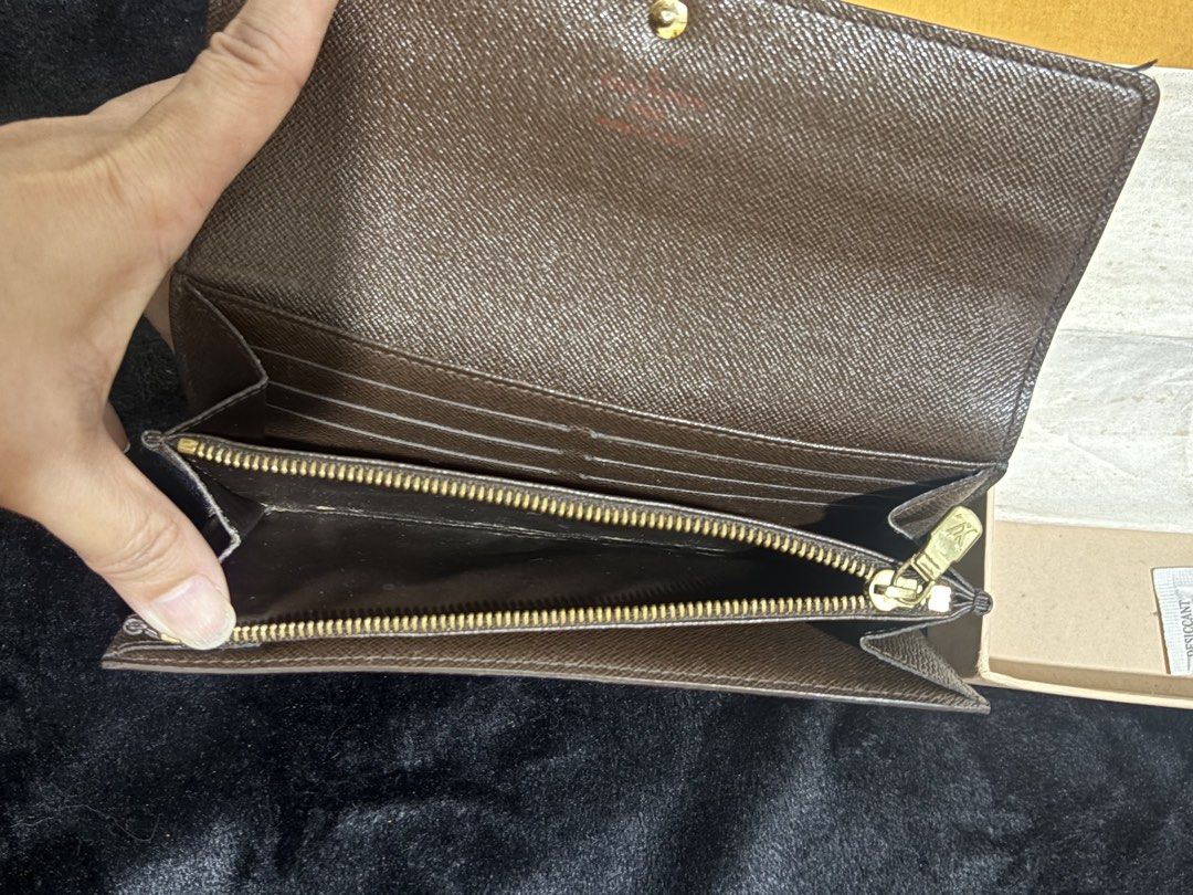Louis Vuitton Damier Ebene Sarah Wallet (Category: Luxury Bags & Wallets) located in Manila. Submitted by nykji96 (Listing ID 1466199543, Image 3). Description: - Authentic Louis Vuitton Damier Ebene Canvas Wallet - Secure snap button front flap closure - Interior features multiple card slots, open compartments, and a zippered middle coin pocket - Elegant gold-tone hardware throughout - Includes original Louis Vuitton box and packaging materials.
