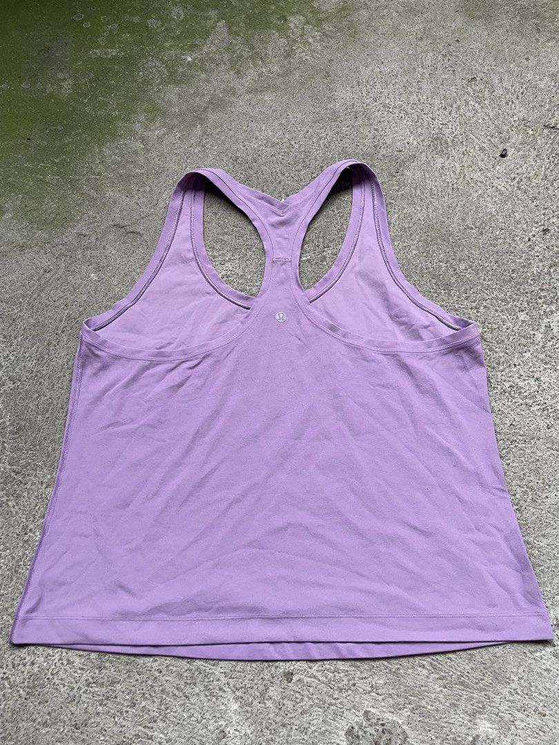 Lululemon Athletic Racerback Tank Top Purple (Category: Activewear) located in Siniloan. Submitted by rethr1ft (Listing ID 1466244986, Image 1). Description: - 22 length | 19 width - Brand: Lululemon - Color: Light purple - Style: Racerback athletic tank top - Details: Classic silver reflective logo on back neckline - Fabric: Soft and stretchy - Condition: Excellent - Perfect for: Workouts, running errands, or pairing with leggings and shorts.