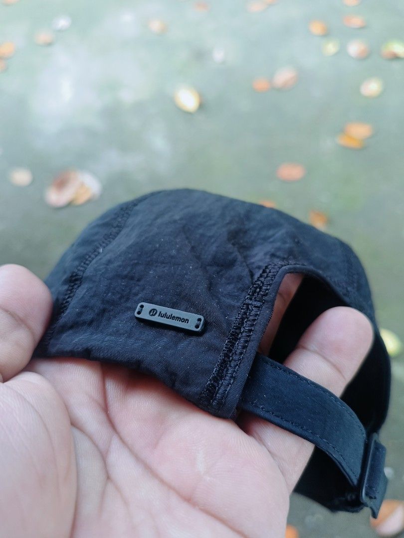 Lululemon Black Athletic Cap (Category: Caps & Hats) located in Narra. Submitted by rhyanguan63087 (Listing ID 1466179961, Image 2). Description: - Brand: Lululemon - Color: Classic Black - Material: Lightweight, water-repellent nylon - Design: Structured front panels, central seam detailing, and curved brim - Fit: Adjustable back strap with secure metal slider - Details: Small side ventilation grommets and rubber logo badge - Condition: Brand ne