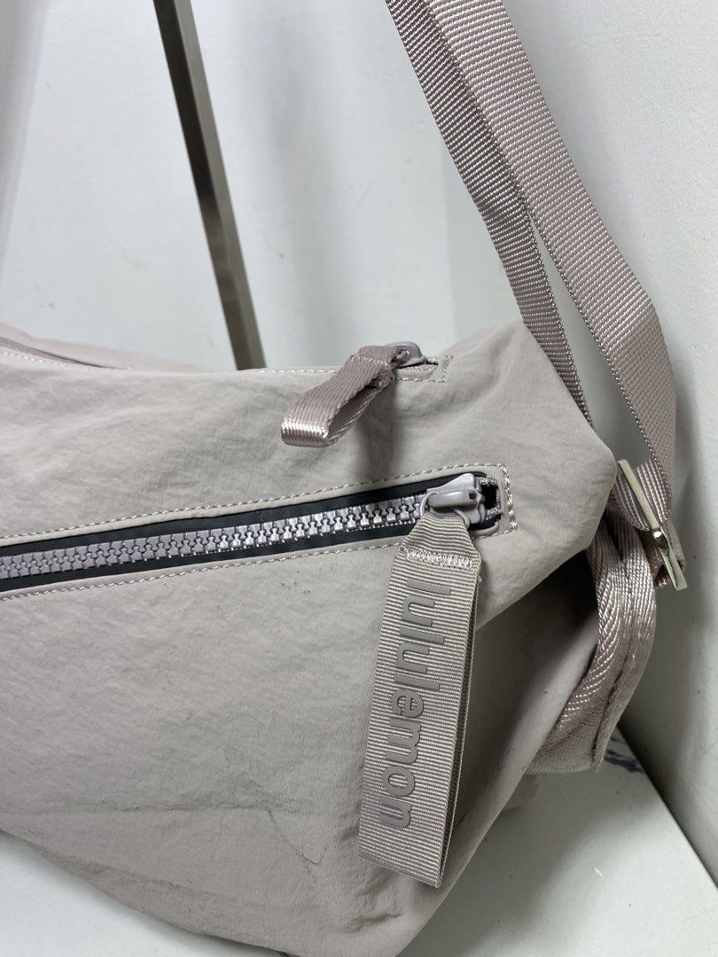 Lululemon Crossbody Bag Light Grey Nylon (Category: Cross-body Bags) located in Manila. Submitted by onfleekapparelph (Listing ID 1466168676, Image 2). Description: - Brand: Lululemon - Style: Crossbody Bag - Material: Durable light grey nylon - Hardware: Premium metallic hardware with adjustable shoulder strap - Pockets: Front diagonal zipper pocket and interior zipper pocket - Details: Features branded pull tab and white Lululemon fabric logo t
